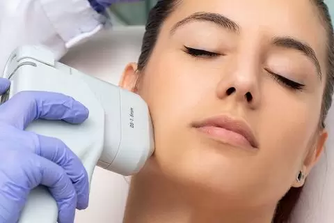 A HIFU handpiece being applied along the jawline during a face treatment